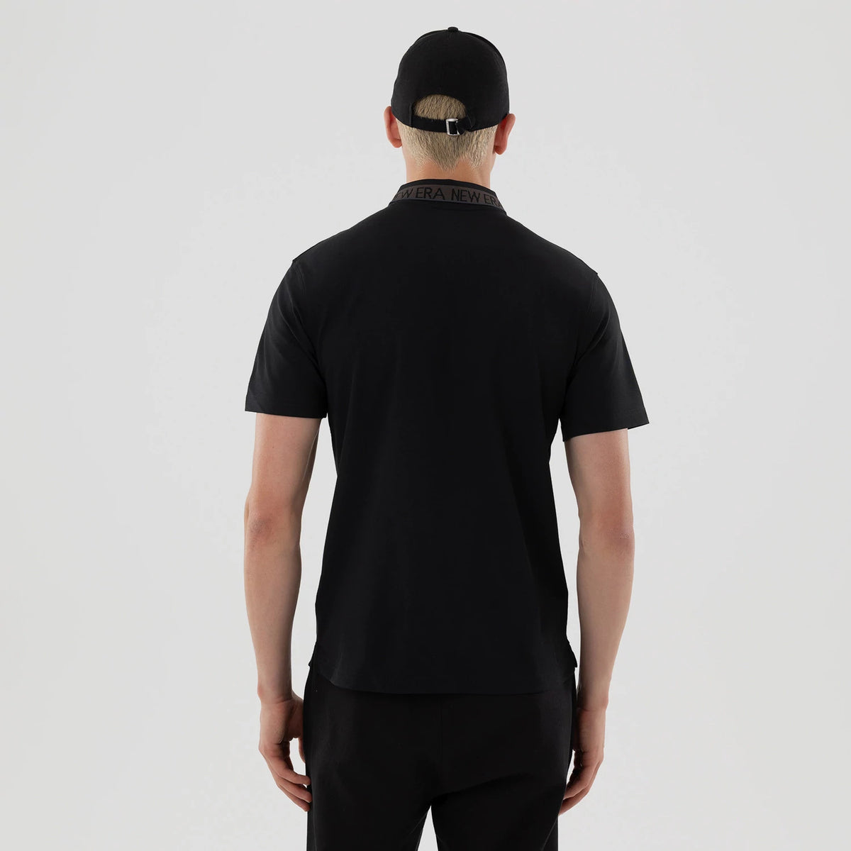 The model is wearing this New Era Kanoko Polo T-Shirt in black. 2