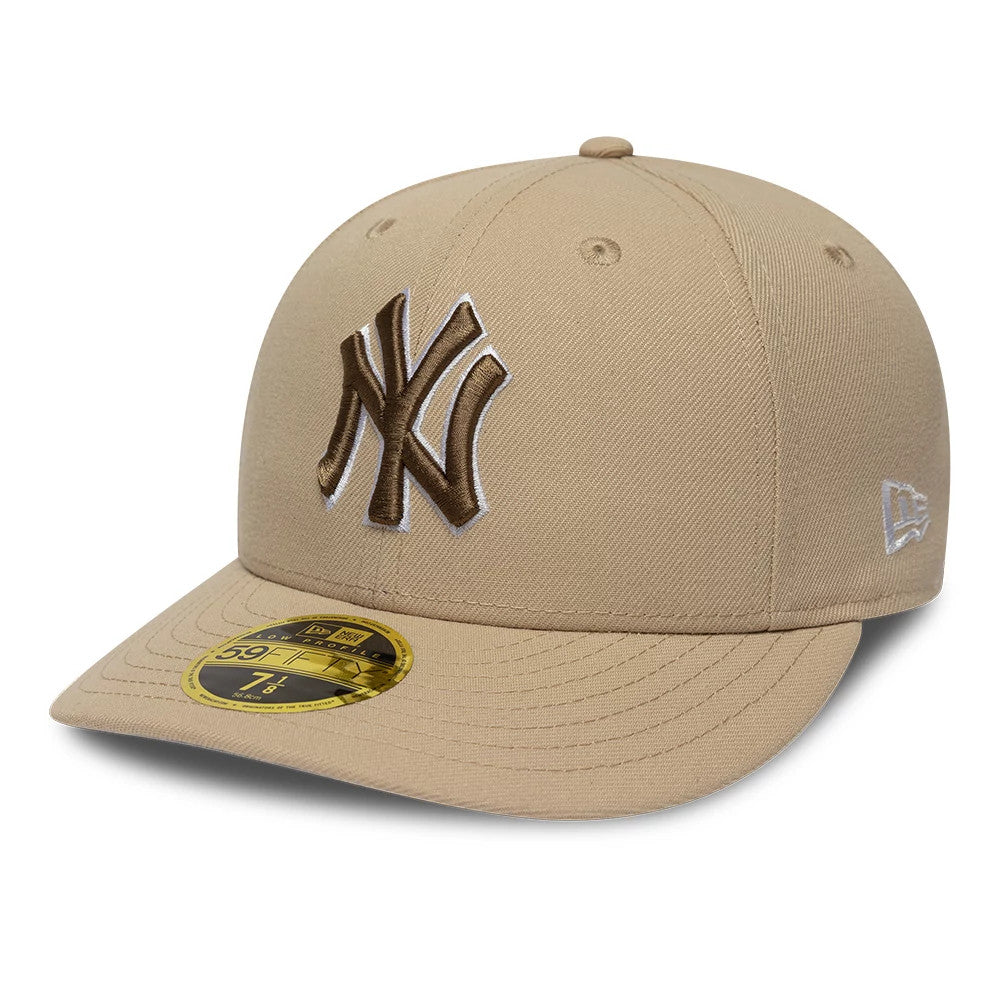 New York Yankees MLB College Varsity Beige Low Profile New Era 59FIFTY Fitted Cap, front view showing brown raised embroidery of the NY logo on the front panel, beige visor with a gold 59FIFTY size sticker, and New Era flag logo on the left side.