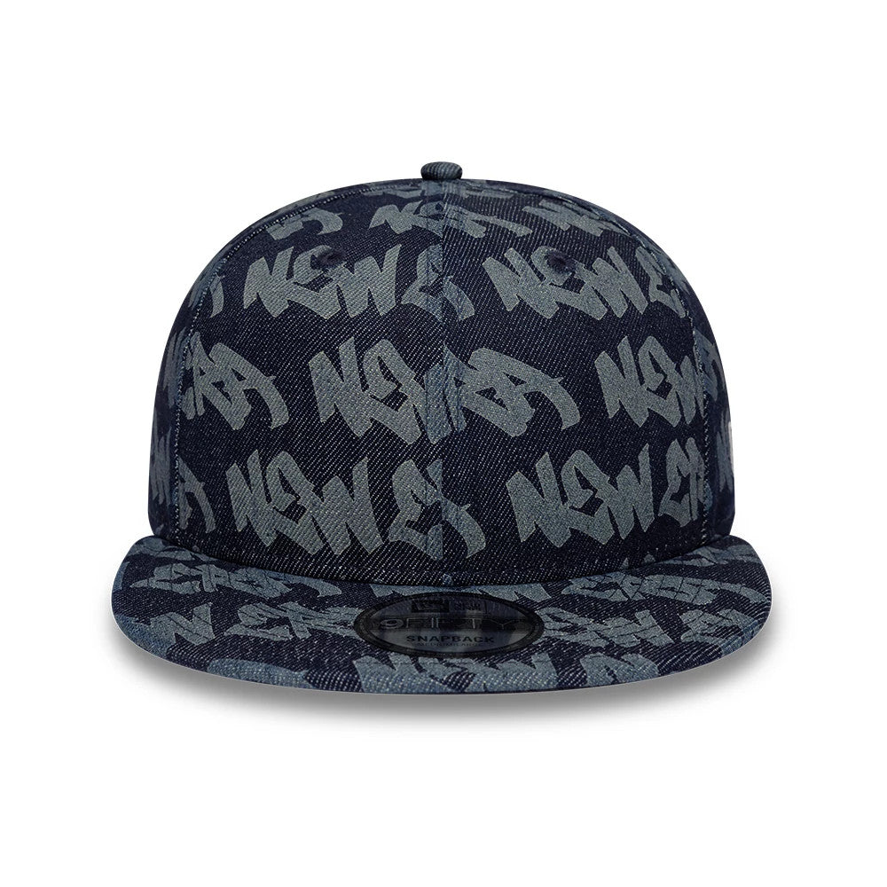 New Era Laser Burnout Denim Navy 9FIFTY Snapback Adjustable Cap, front view showing large graffiti-style New Era lettering across the denim crown and visor, with a black 9FIFTY size sticker on top of the flat visor.