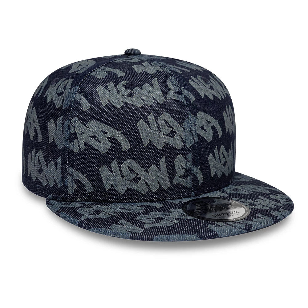 New Era Laser Burnout Denim Navy 9FIFTY Snapback Adjustable Cap, front view showing the raised graffiti-style New Era script embroidered in grey on the navy denim panels and a 9FIFTY size sticker on the flat visor.