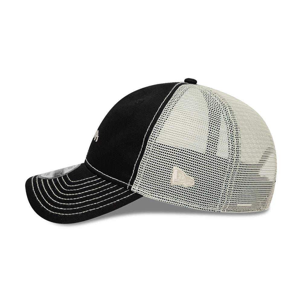 New Era Tagging Logo Black New Era 9TWENTY Trucker Adjustable Cap, side view showing the embroidered New Era flag logo on the left mesh panel, with a curved black visor and distinct white stitching along the crown and visor edge.