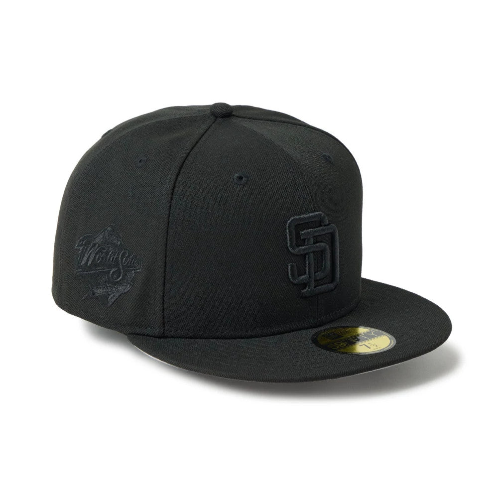 San Diego Padres MLB Black New Era 59FIFTY Fitted Cap, three-quarter view with raised black SD logo on the front panel, World Series logo on the left side, and gold 59FIFTY size sticker on the visor.