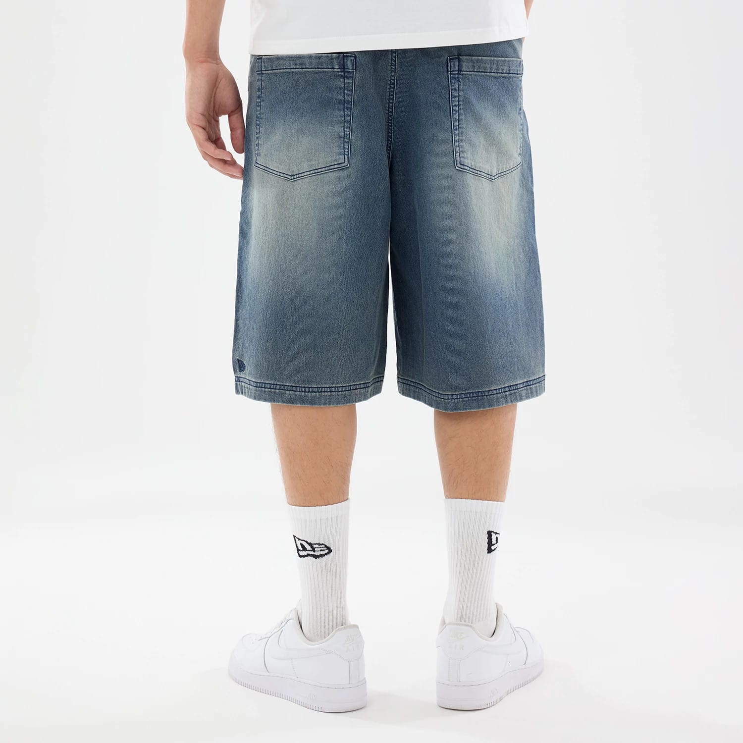 The model is wearing this New Era Washed Bermuda Shorts in blue. 2