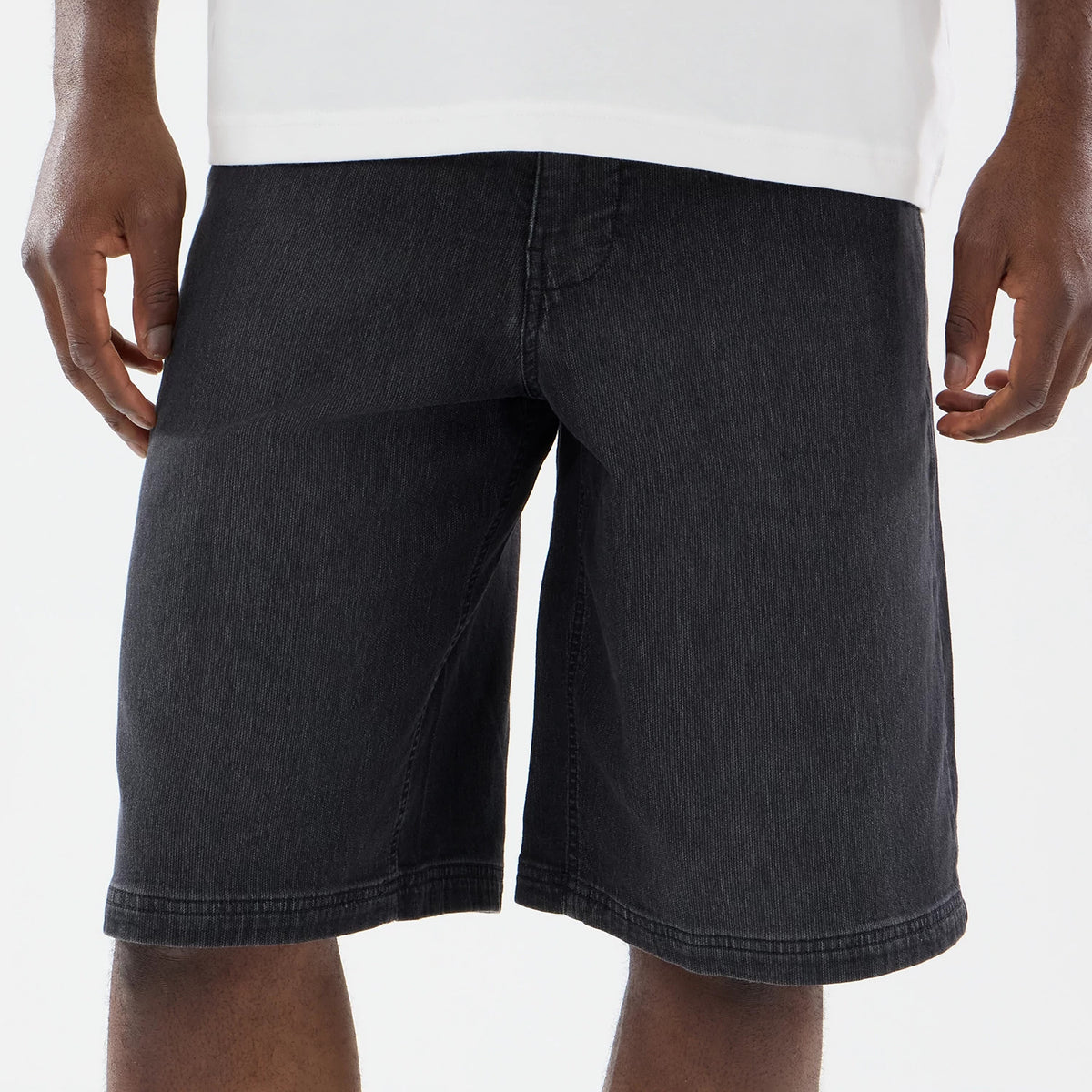 The model is wearing this New Era Washed Bermuda Shorts in black. 3