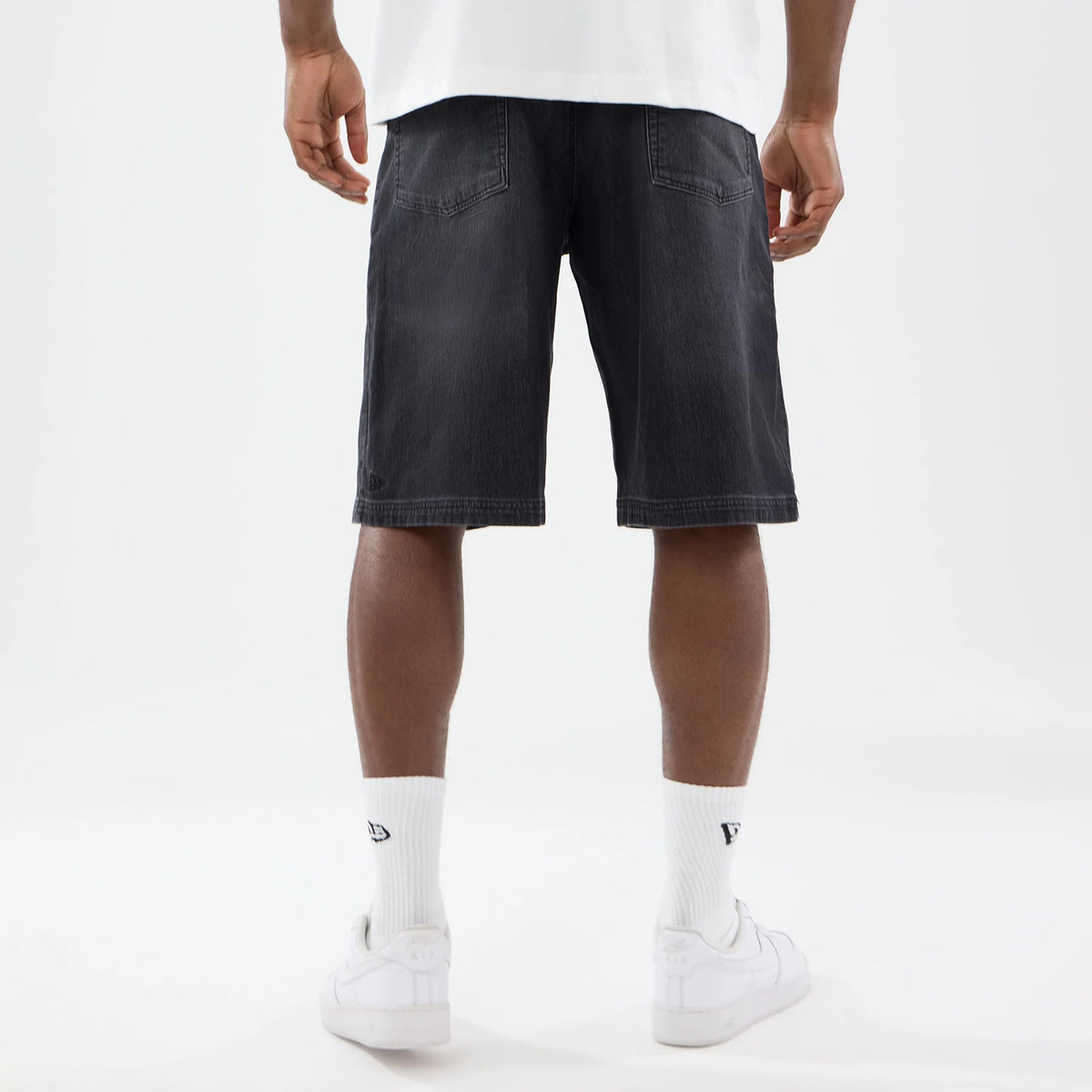 New Era Washed Black Bermuda Shorts, rear view showing faded black fabric with two back pockets, subtle seam details, and a straight hem falling just above the knee.