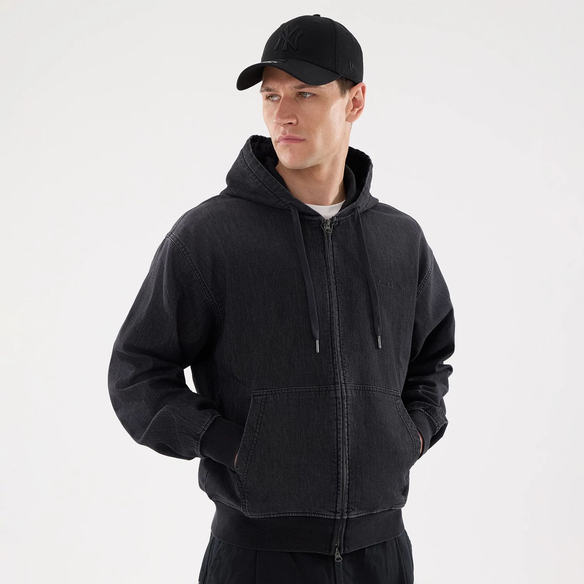 The model is wearing this New Era Washed Full Zip Hoodie in black. 1