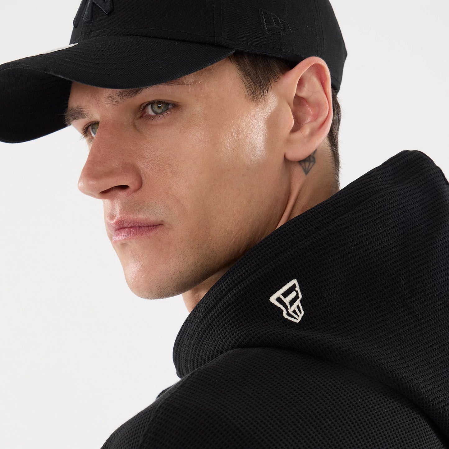 The model is wearing this New Era Waffle Full Zip Hoodie in black. 7