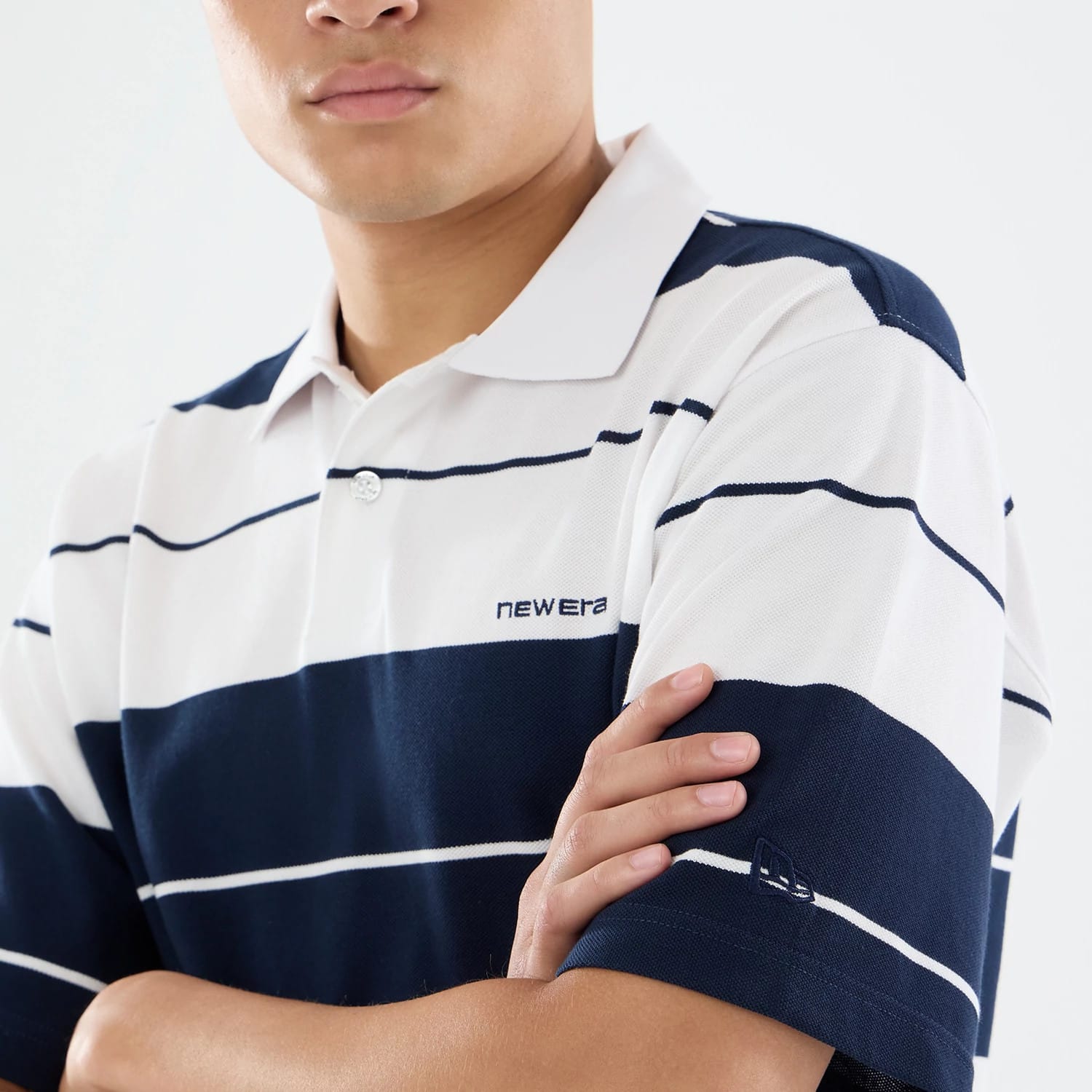 The model is wearing this New Era Stripe Polo T-Shirt in white. 3
