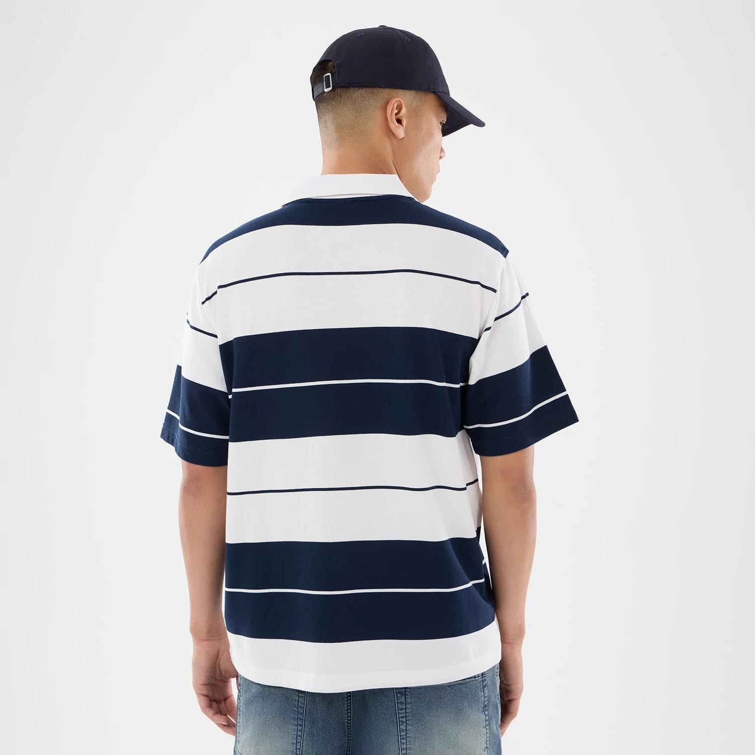 The model is wearing this New Era Stripe Polo T-Shirt in white. 2