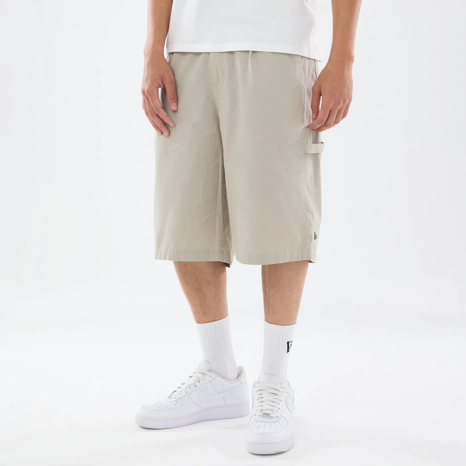 The model is wearing this New Era Canvas Bermuda Shorts in grey. 1