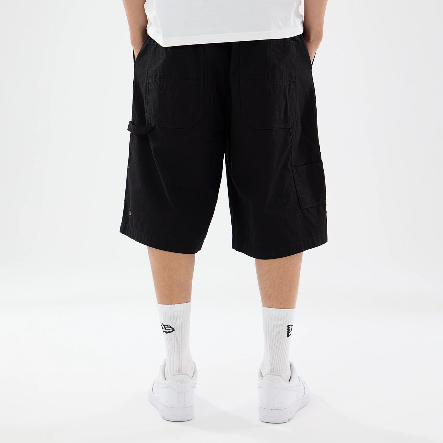 The model is wearing this New Era Canvas Bermuda Shorts in black. 2
