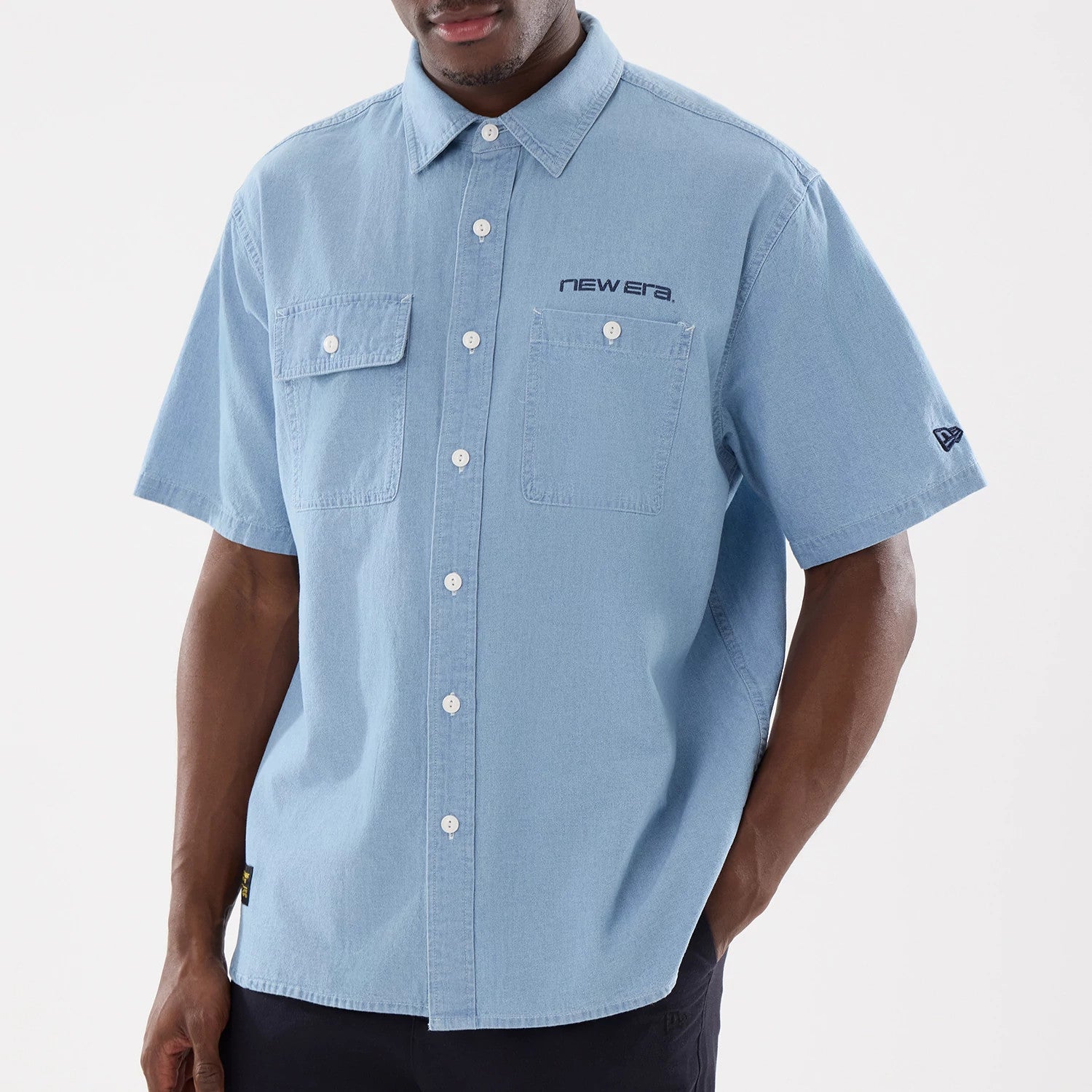 The model is wearing this New Era Originators Chambray Short Sleeve Shirt in bright blue. 3