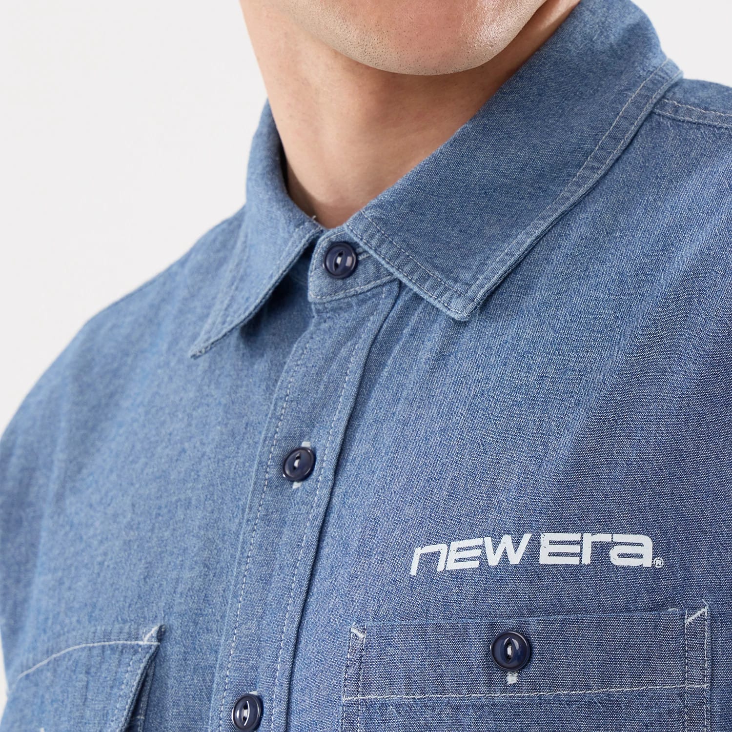 The model is wearing this New Era Originators Chambray Short Sleeve Shirt in dark blue. 4