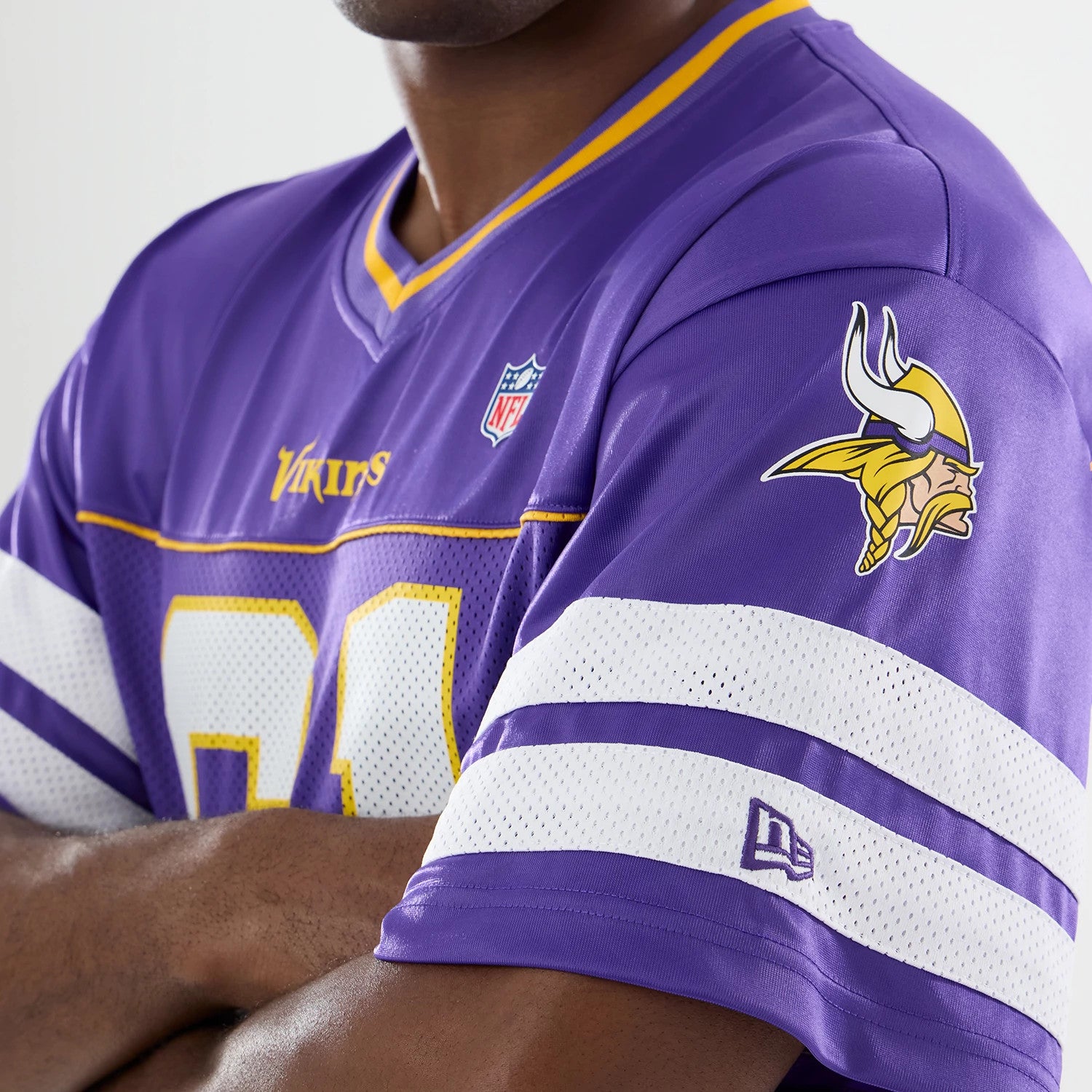 Minnesota Vikings NFL Purple Mesh Jersey, on a model showing the team logo on the right sleeve, the NFL shield logo on the chest, and white mesh detailing with stripes across the upper arms.
