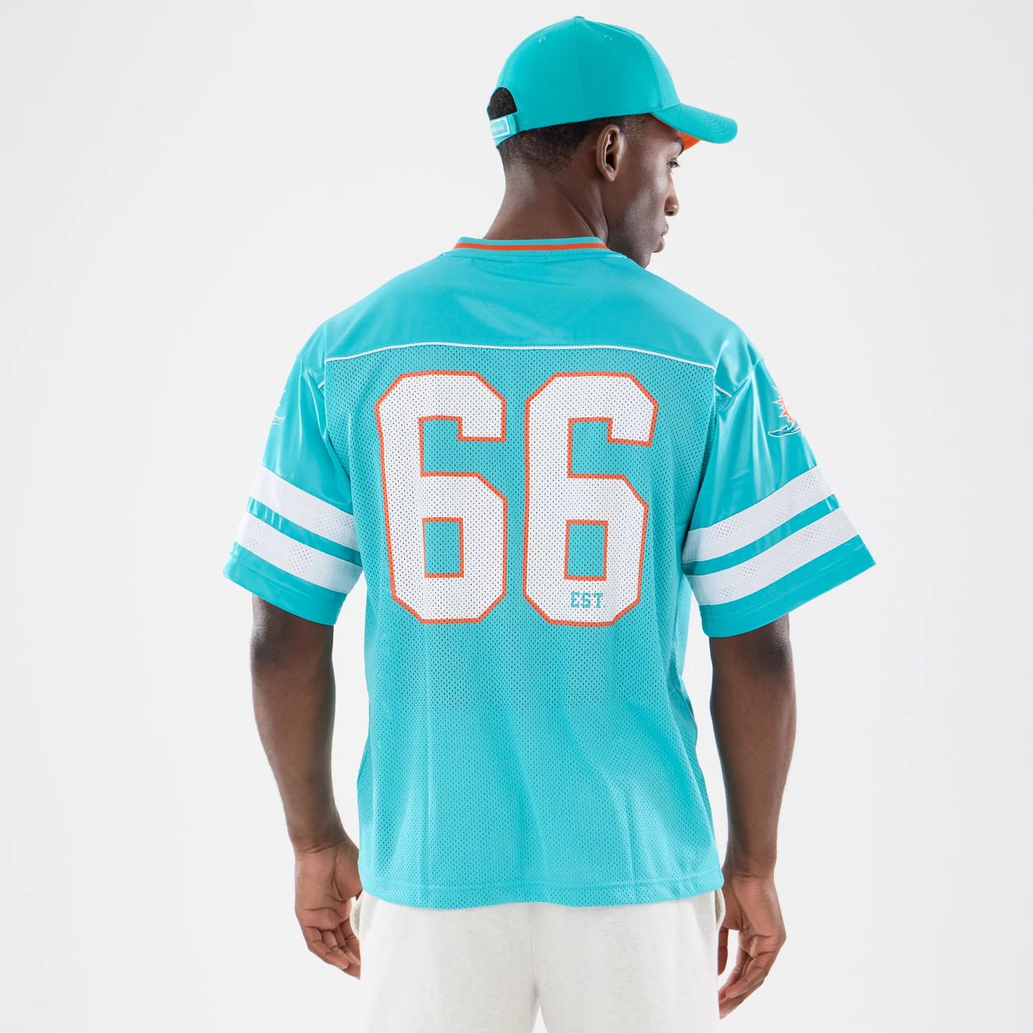 The model is wearing this NFL Miami Dolphins Mesh Jersey in turquoise. 2