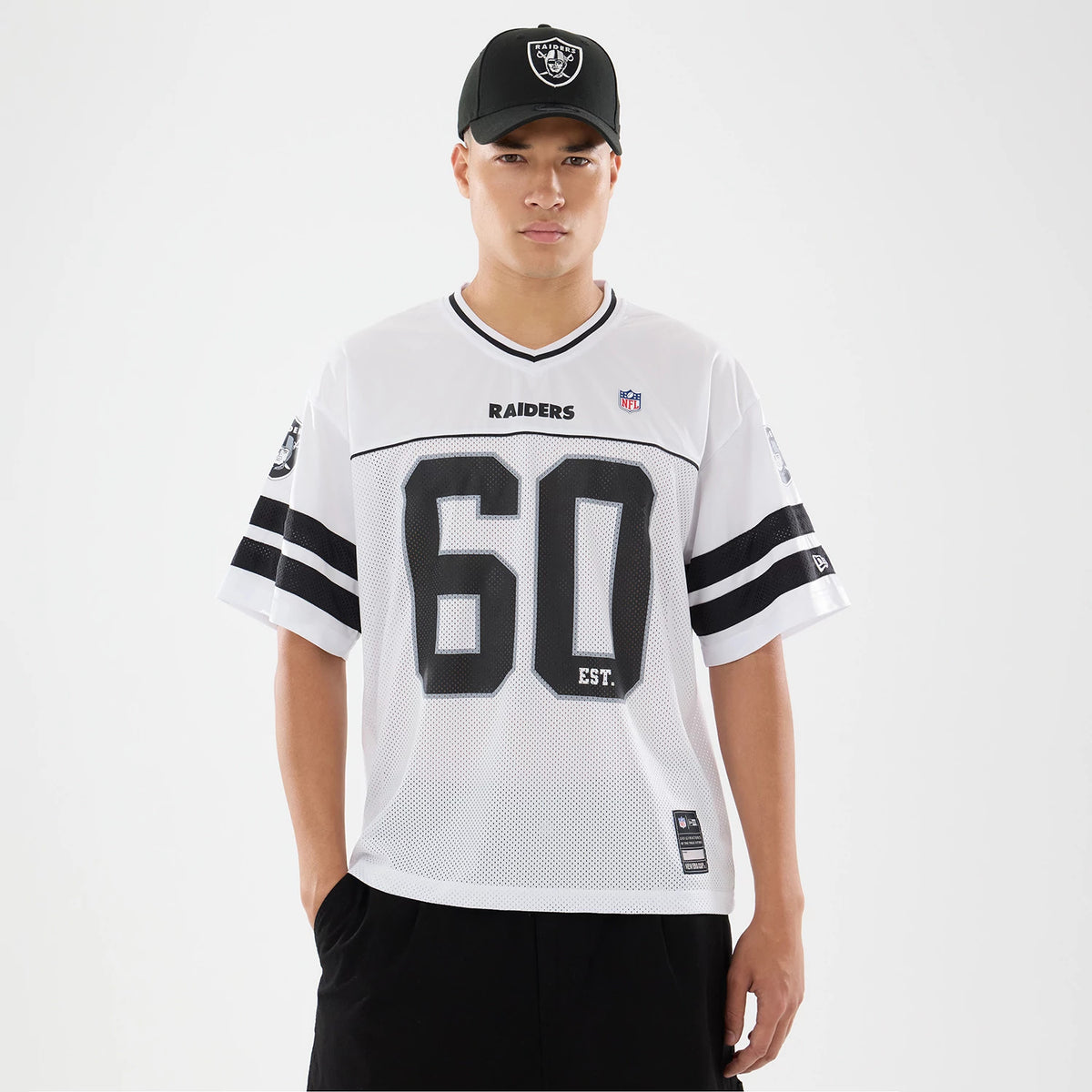 Las Vegas Raiders NFL White Mesh Jersey, front view on a model with a black cap, featuring black "RAIDERS" lettering across the chest, large black "60" numbers, and black and white striped sleeves with the Raiders logo on the shoulders.