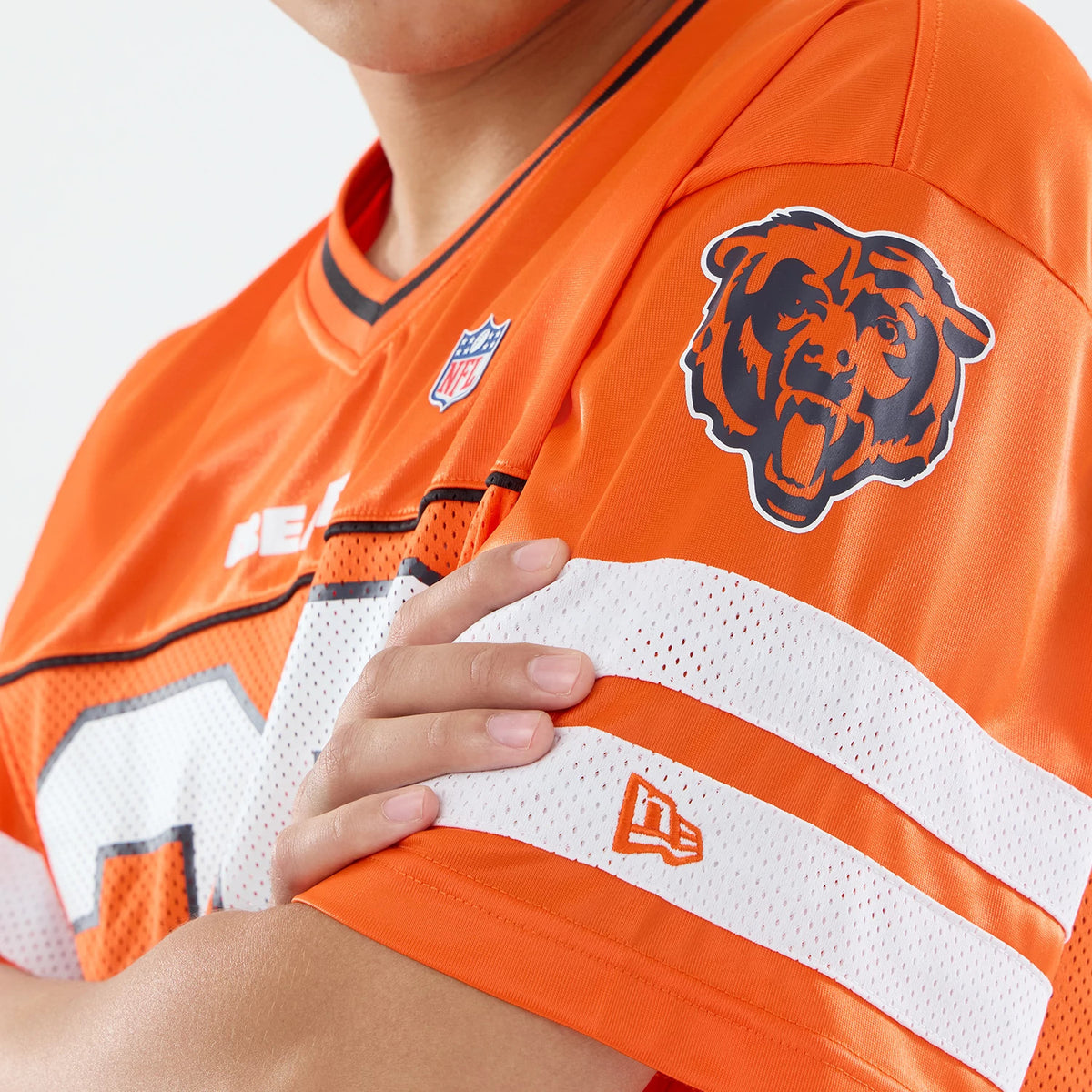 Chicago Bears NFL Orange Mesh Jersey, close-up on a model showing the sleeve details with the New Era flag logo and the embroidered Bears logo on the shoulder, above a white mesh stripe.