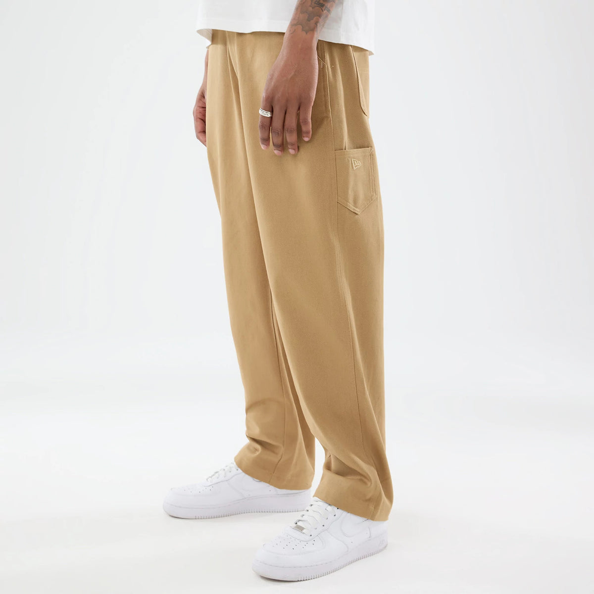 The model is wearing these New Era Work Pants in beige. 1