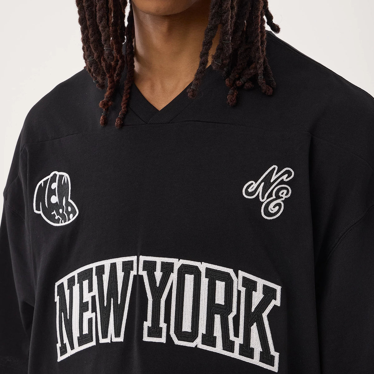 New Era Fan Family Black Jersey, front view on a model featuring New York lettering across the chest, with embroidered NE logo on the right side and a stylized cap logo on the left shoulder.