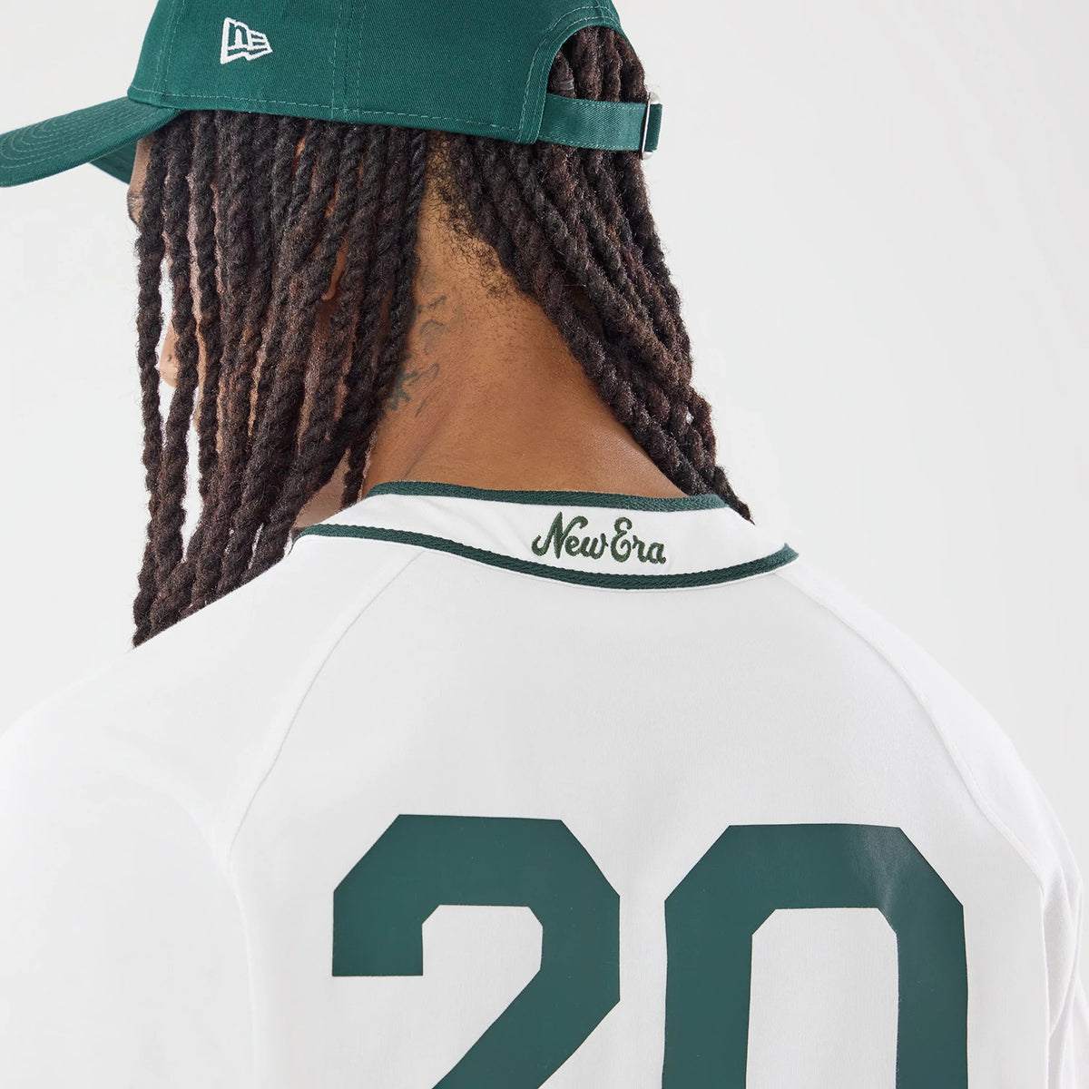 New Era New York White Jersey, back view on a model wearing a green cap, showing the green embroidered New Era script below the collar and the number 20 in large green font on the white fabric.