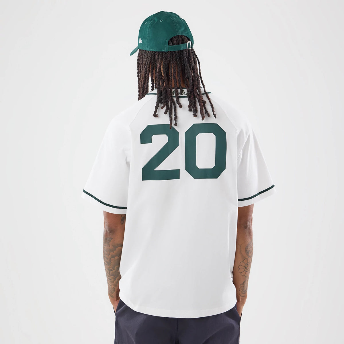 New Era New York White Jersey, back view on a model with long hair wearing a dark green cap, featuring large green number 20 on the back of the jersey and contrasting green trim on the sleeves and collar.