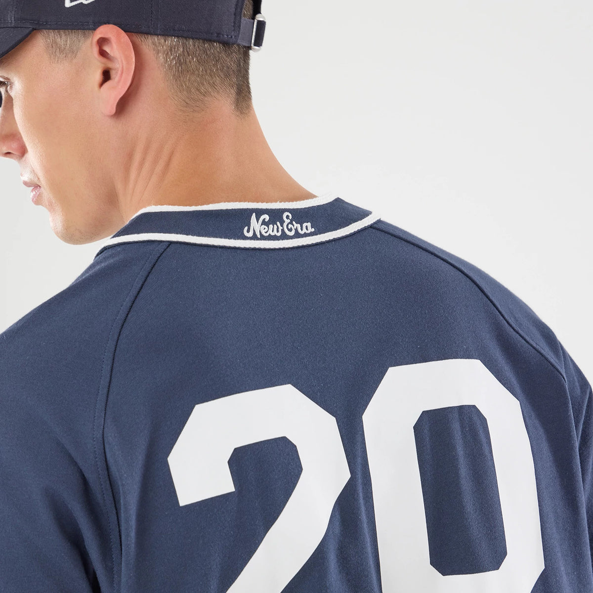New Era New York Navy Jersey, back view on a model wearing a navy cap, featuring the number 20 in white on the jersey, a white embroidered New Era logo on the collar, and contrast white piping.