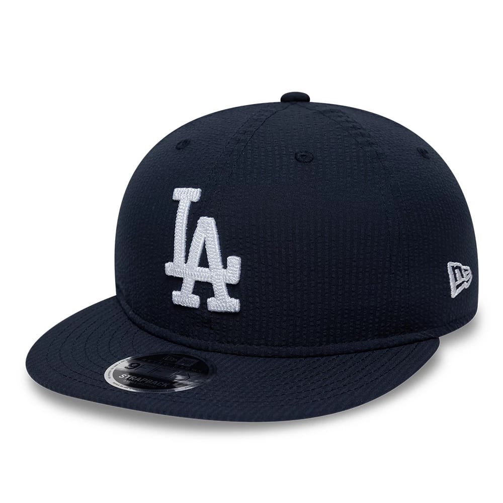 LA Dodgers MLB Seersucker Navy Retro Crown New Era 9FIFTY Adjustable Cap, three-quarter view showing the white embroidered LA logo on the front panel, navy curved visor with 9FIFTY size sticker, and New Era flag logo on the left side.
