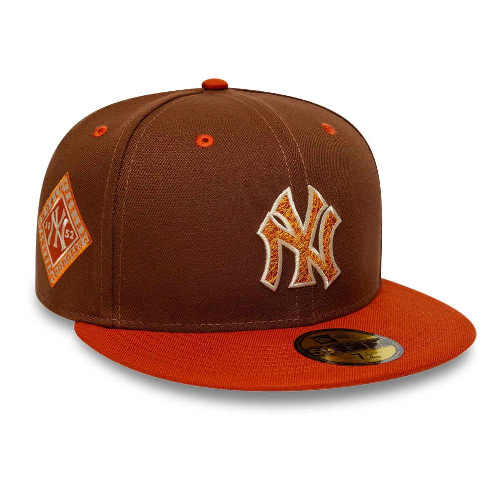 New York Yankees MLB Pack Brown New Era 59FIFTY Fitted Cap, front view showing the raised embroidered NY logo in orange and white on the front panel with an orange flat visor, matching eyelets, and gold 59FIFTY size sticker.
