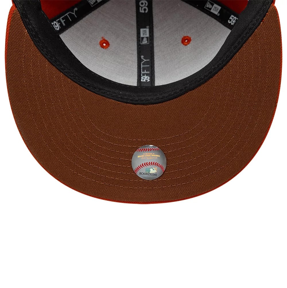 Chicago Cubs MLB Pack Dark Orange New Era 59FIFTY Fitted Cap, inside view showing black and grey 59FIFTY taping, orange eyelets on the white sweatband, and an MLB authentication sticker on the brown undervisor.