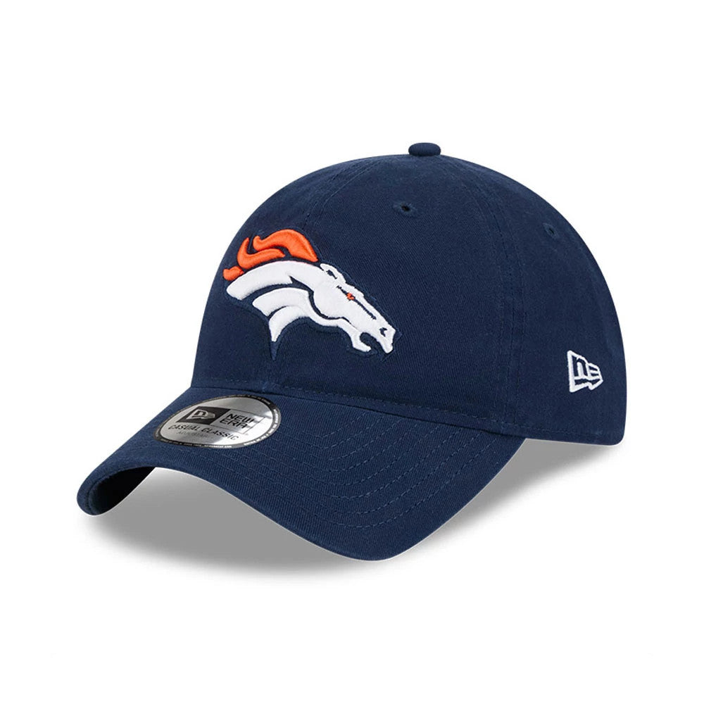 Denver Broncos NFL X Bad Bunny Navy New Era Casual Classic Adjustable Cap, front view showing the raised orange and white embroidered Broncos logo on the structured crown, navy curved visor, and metallic sticker.
