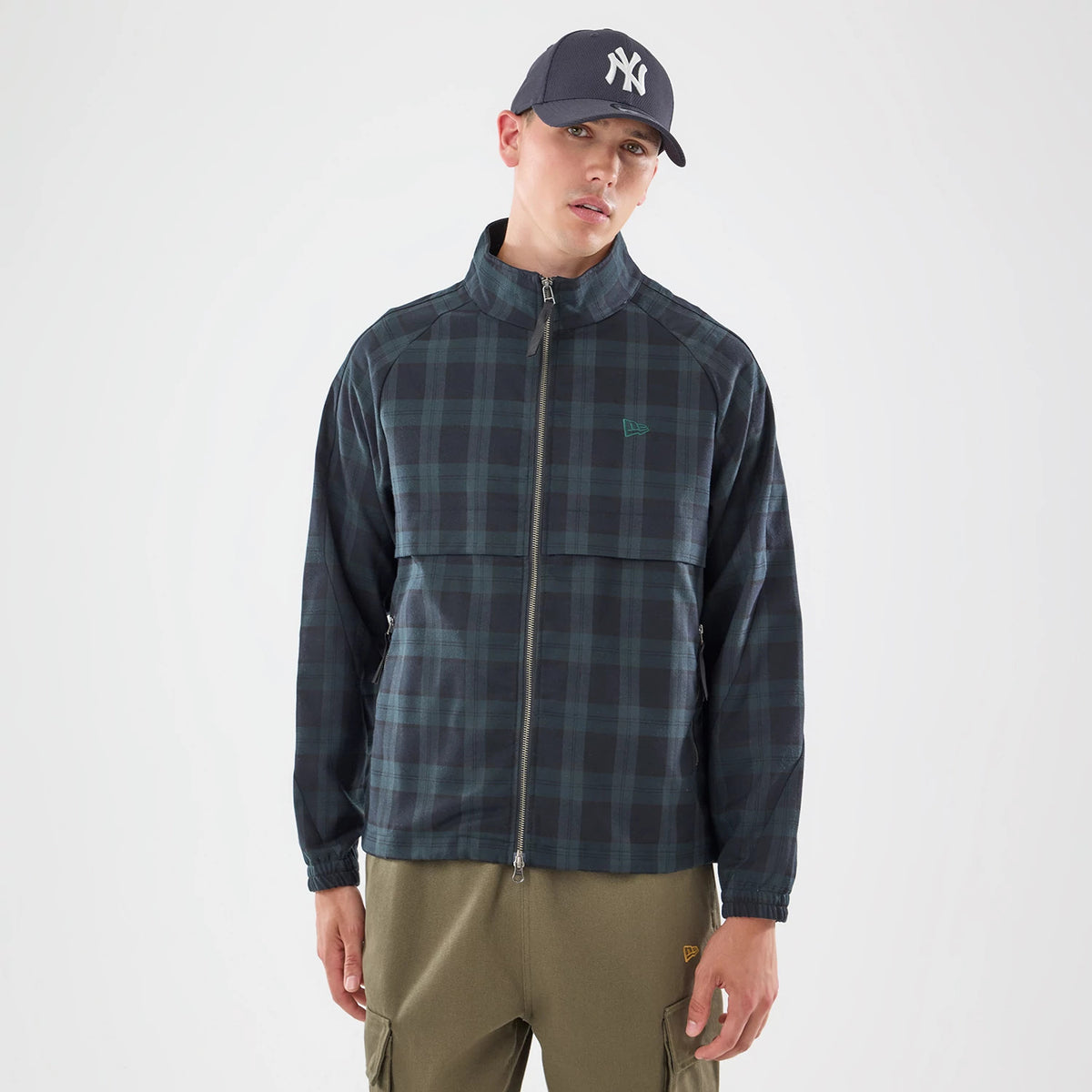 The model is wearing this New Era Blouson Plaid Windbreaker Jacket in Navy. 1