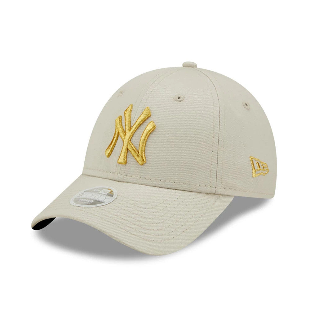 New York Yankees Womens Metallic Logo Cream New Era 9FORTY Adjustable Cap, three-quarter view with a raised gold NY logo on the front panel, a New Era flag logo on the left, and a 9FORTY size sticker on the cream curved visor.