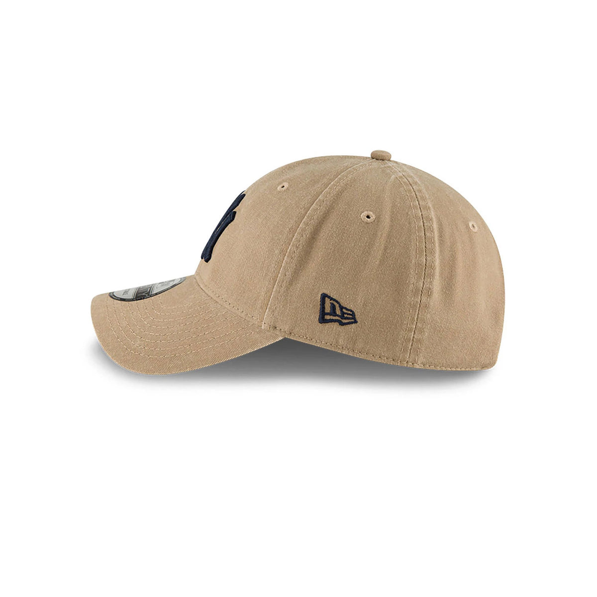 New York Yankees MLB Core Classic Beige New Era 9TWENTY Adjustable Cap, side view showing the navy embroidered New Era flag logo on the left side and a curved visor with a 9TWENTY size sticker on top.
