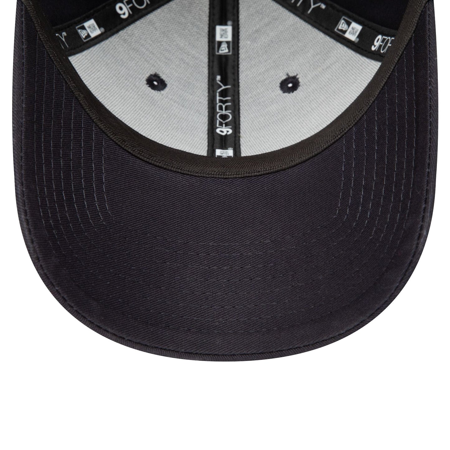 Red Bull Essential Navy New Era 9FORTY Adjustable Cap, inside view showing 9FORTY taping along the seams, a black sweatband, and grey undervisor with navy stitching, highlighting the structured design and attention to detail.