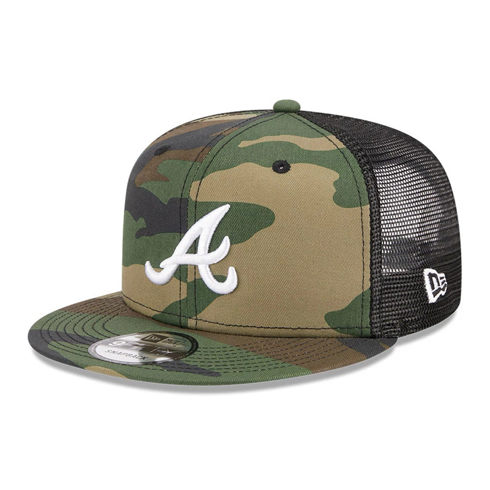 Atlanta Braves MLB Evergreen Camo New Era 9FIFTY Trucker Adjustable Cap, front view with a white embroidered A logo on the camo front panels, black mesh back panels, and a 9FIFTY size sticker on the camouflage visor.