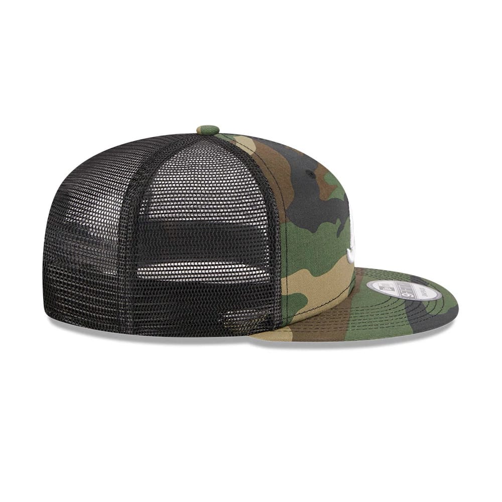 Atlanta Braves MLB Evergreen Camo New Era 9FIFTY Trucker Adjustable Cap, side view showing the white raised embroidered A logo on the front panel, with a black mesh backing and a camo visor featuring a 9FIFTY size sticker.