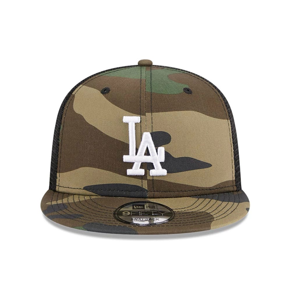 LA Dodgers MLB Evergreen Camo New Era 9FIFTY Trucker Adjustable Cap, front view showing raised white LA logo embroidered on camo print, with a black mesh back and 9FIFTY size sticker on the camo visor.