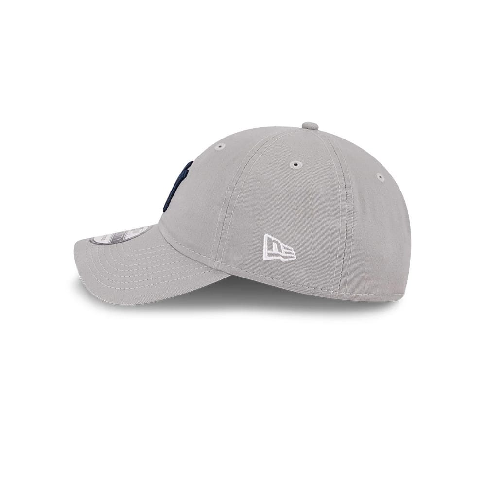 New York Yankees MLB Evergreen Grey New Era 9TWENTY Adjustable Cap, side view showing the white embroidered New Era flag logo on the left side of the unstructured grey crown and a 9TWENTY size sticker on the grey curved visor.