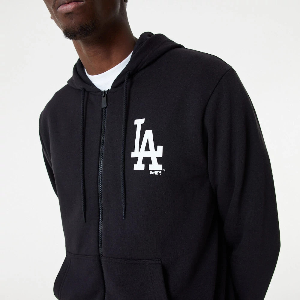 LA Dodgers MLB Essential Black Full Zip Hoodie, front view showing a white LA logo embossed on the left chest, a full-length zip running down the centre, and a hood with drawstrings, worn over a white shirt.