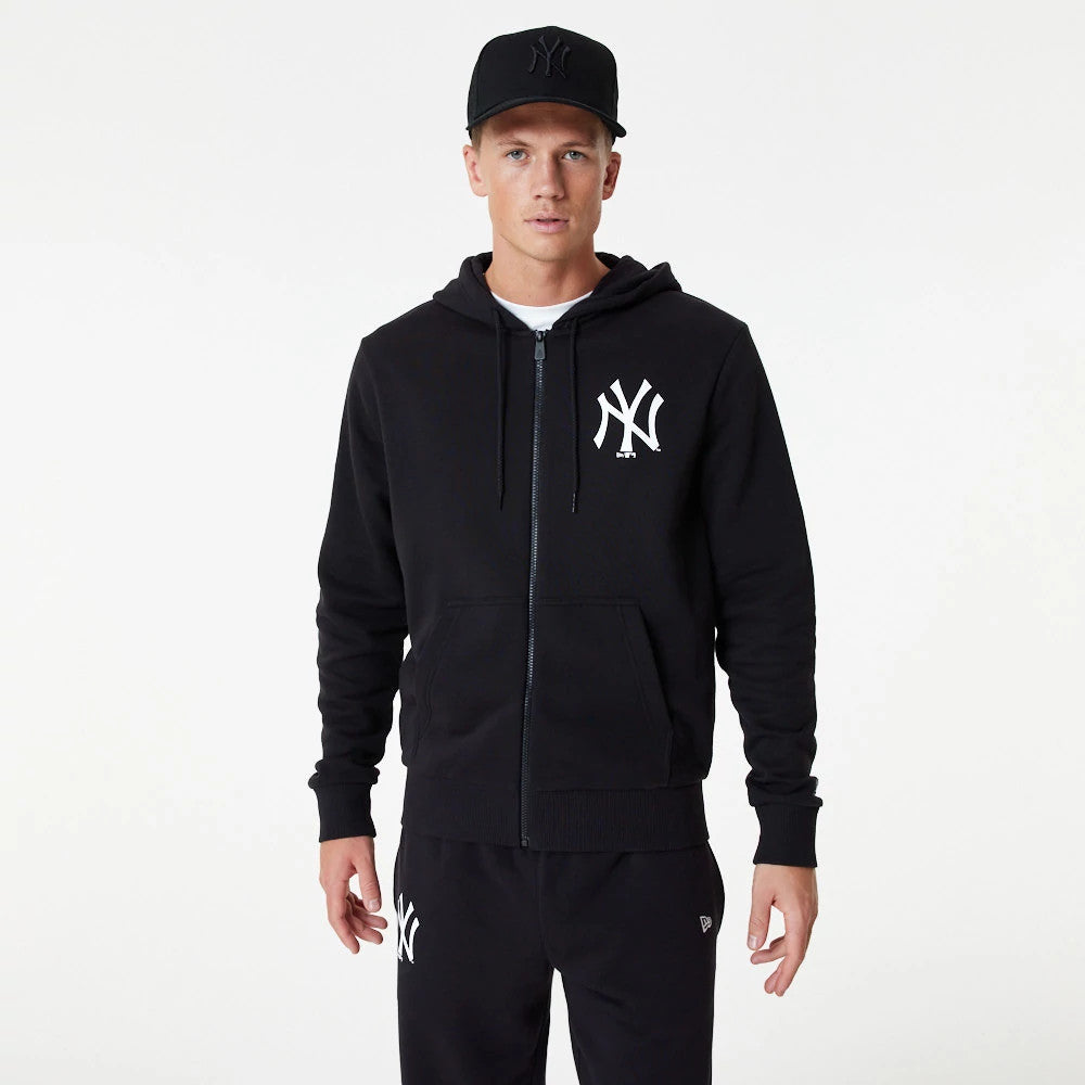 New York Yankees MLB Essential Black Full Zip Hoodie, on-model view showing the front with a full zip closure, a white NY logo on the left chest, and a raised black New Era logo on a matching black cap worn by the model.