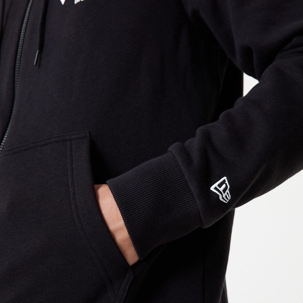 New York Yankees MLB Essential Black Full Zip Hoodie, side view showing a hand in the front pocket, a raised New Era logo embroidered in white on the wrist cuff and and the edge of the black zip running up the front.