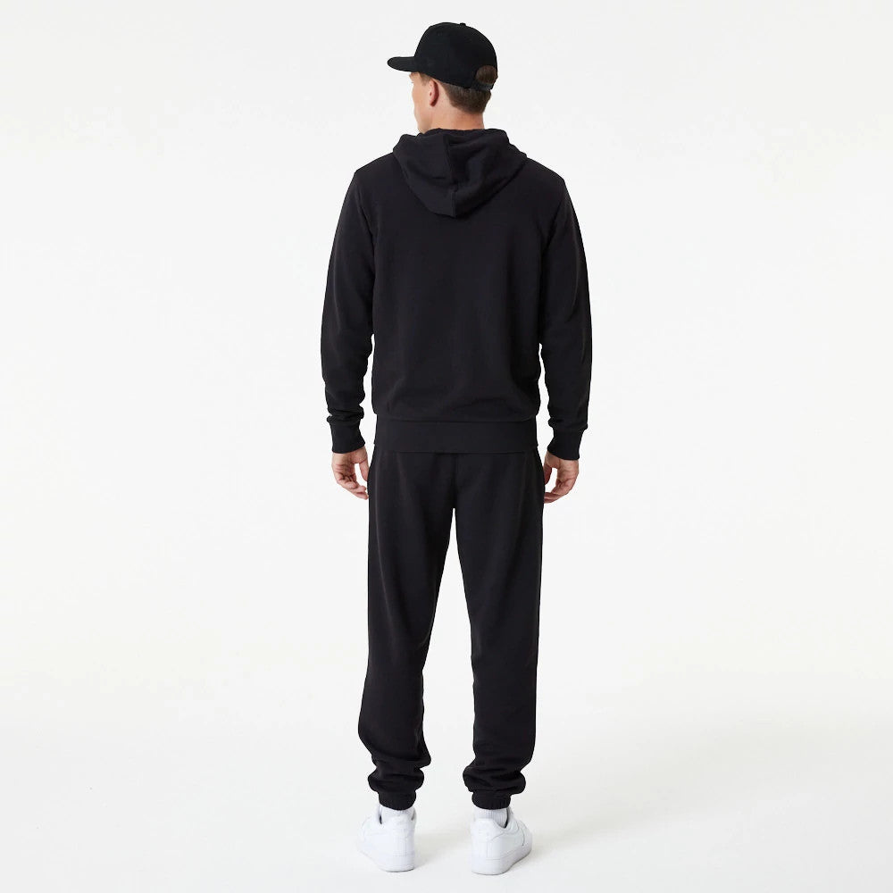 New York Yankees MLB Essential Black Full Zip Hoodie, rear view showing the black hoodie with a hood up, worn by a model paired with black trousers and white sneakers, a black cap on their head.