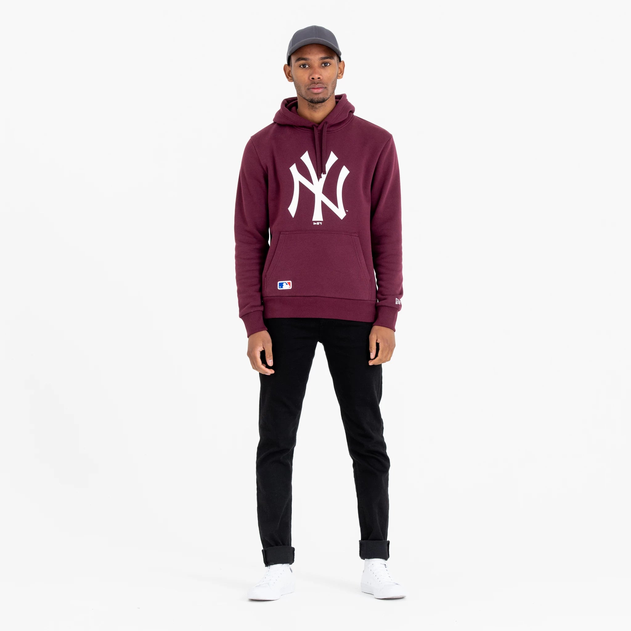 New York Yankees MLB Regular Dark Purple Pullover Hoodie, on-model view showing the white New York Yankees logo prominently centred on the chest, a small MLB patch near the hem, and a debossed New Era logo on the left sleeve.
