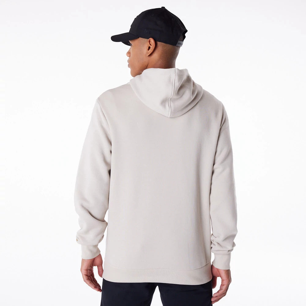 New York Yankees MLB Regular Light Beige Pullover Hoodie, rear view showing the light beige fabric with a relaxed hood and ribbed cuffs, on-model paired with a black cap featuring a debossed New Era logo on the side.