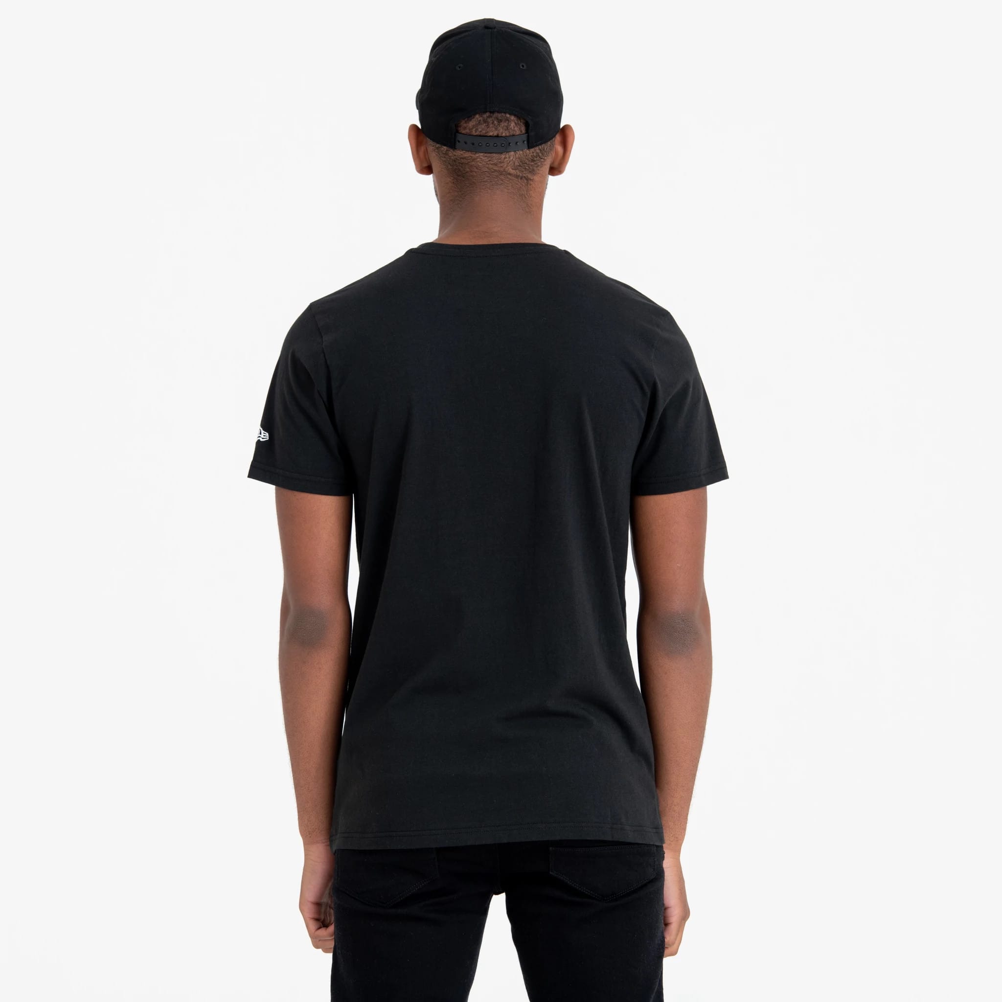 New York Yankees MLB Regular Black T-Shirt, rear view showing the black fabric with a short-sleeve design, an embroidered white New Era logo on the left sleeve, and the back of a black cap with eyelets on the head.