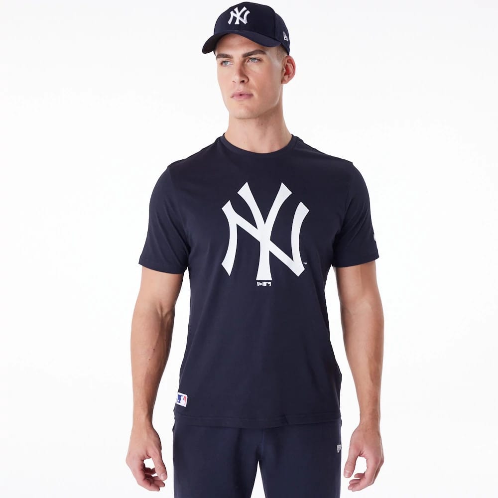 New York Yankees MLB Regular Navy T-Shirt, on-model view showing a large white Yankees logo printed on the chest, paired with a navy cap featuring a raised white New Era logo on the side.