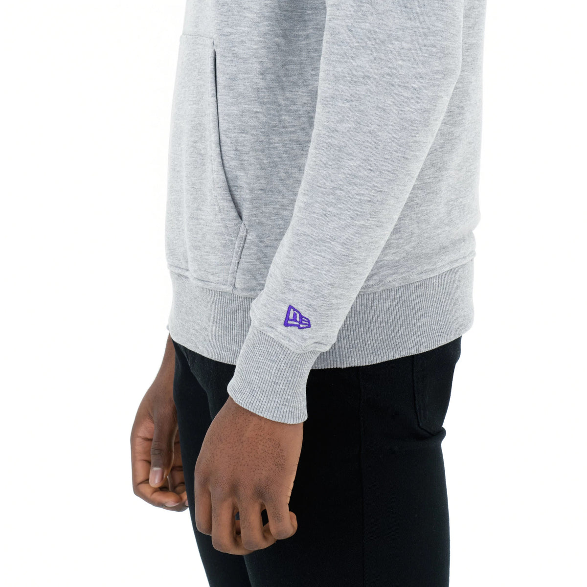 LA Lakers NBA Regular Grey Pullover Hoodie, side view showing the light grey fabric with a raised purple New Era logo on the lower sleeve above the ribbed cuff, and a front pocket slightly visible.