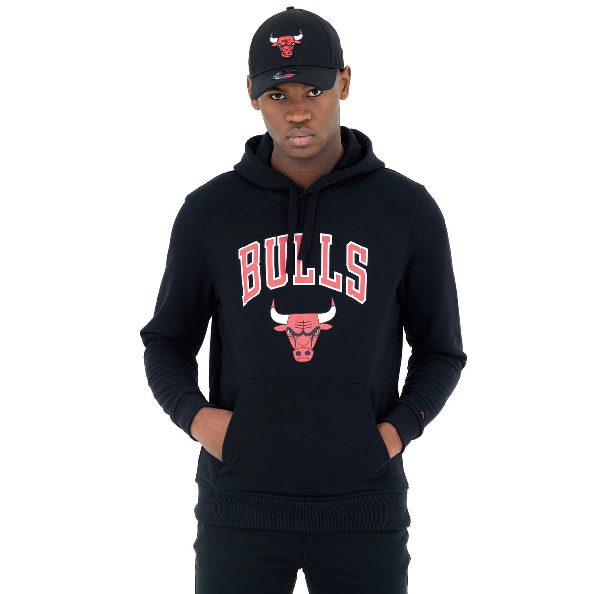 Chicago Bulls NBA Regular Black Pullover Hoodie, on-model view showing the red and white Bulls logo and lettering on the chest, with a man wearing a black cap featuring a raised red Bull logo.