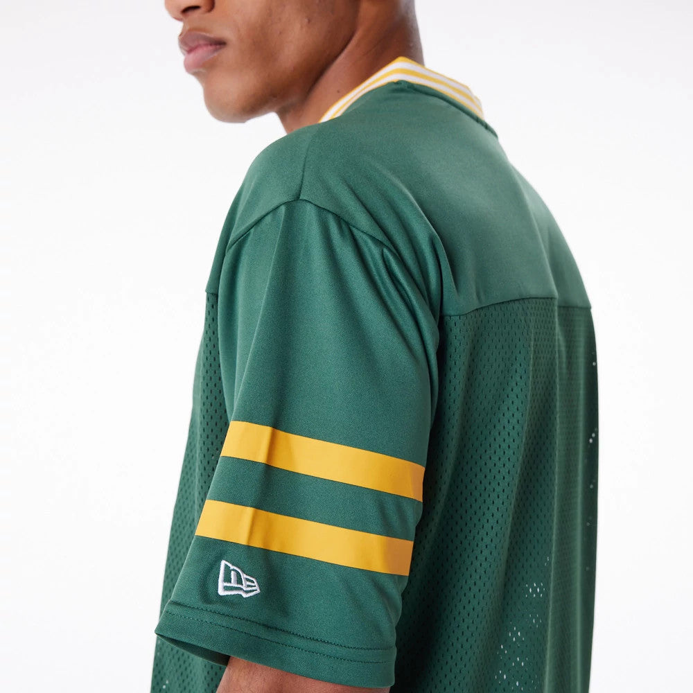 New Era Green Bay Packers NFL Dark Green Mesh T-Shirt, three-quarter view showing dark green fabric with yellow stripes on the sleeve and an embroidered New Era logo near the cuff, mesh back panel for contrast.