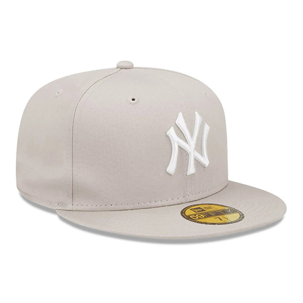 New York Yankees League Essential Stone New Era 59FIFTY Fitted Cap, front view showing the raised white embroidered NY logo on the front panel and a gold 59FIFTY size sticker on the flat stone-coloured visor.